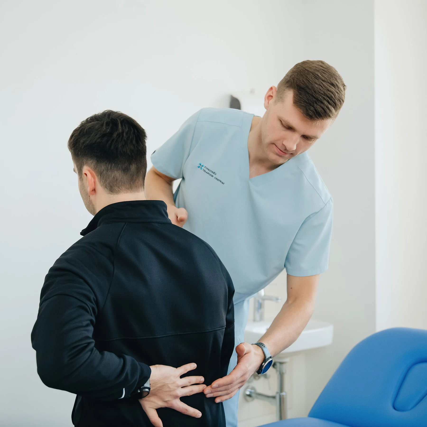 Physiotherapist assessing a patient with low back pain